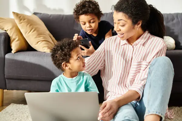 Joyeuse jolie mère afro-américaine regardant ses deux fils avec amour en regardant des films — Photo de stock