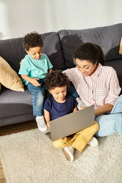 Jolly appealing african american mother watching movies together with her cheerful cute sons — Stock Photo