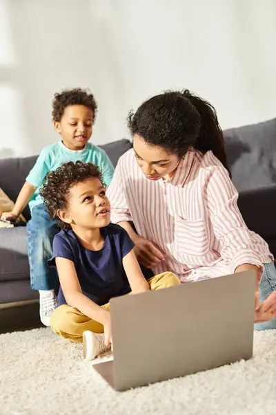 Allegro adorabile afro-americano ragazzi in homewear trascorrere del tempo con la madre vicino al computer portatile — Foto stock