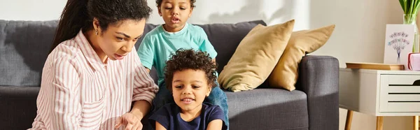 Pouco bonito afro-americano meninos passar tempo com sua bela mãe na sala de estar, banner — Fotografia de Stock