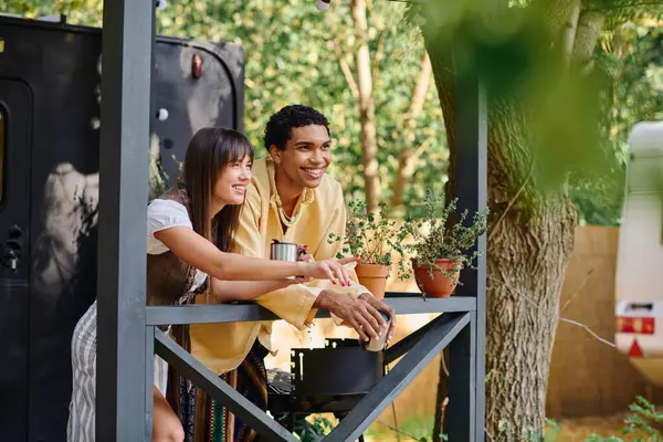 A man and woman sit next to a tree on a porch, enjoying the serene natural surroundings. — Stock Photo
