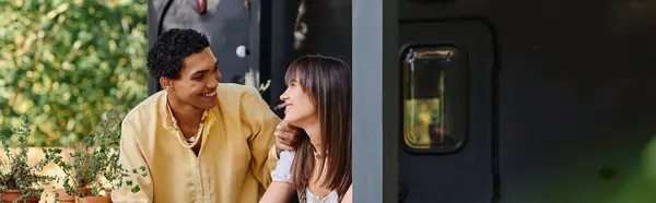 A man and a woman stand outside a train, gazing into each others eyes with a look of love and adventure. — Stock Photo