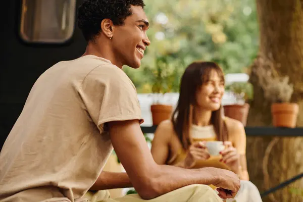 Un couple interracial profite d'un moment de calme ensemble, assis côte à côte sur un banc. — Photo de stock