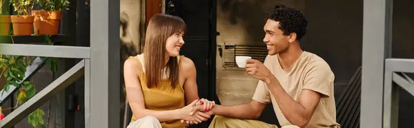 A man and woman sitting peacefully on a porch, enjoying each others company and the tranquil surroundings. — Stock Photo