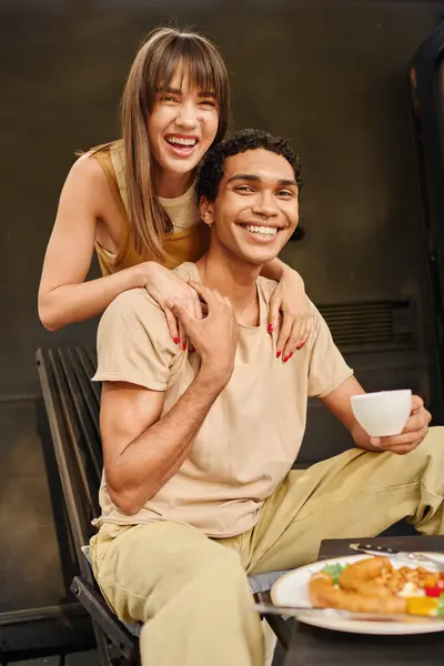 An interracial couple enjoying a romantic lunch together in a camper van. — Stock Photo