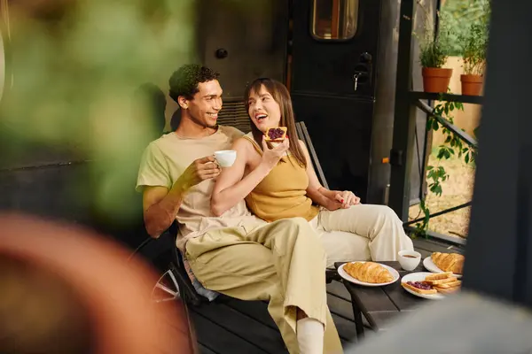 An interracial couple sits peacefully on a porch, enjoying each others company in a serene moment. — Stock Photo