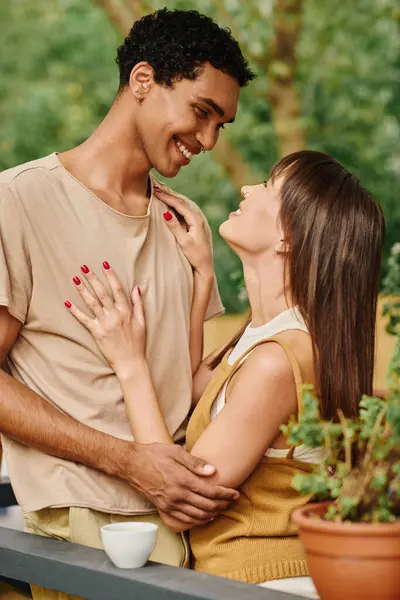 Una coppia interrazziale sta insieme, abbracciando di fronte a un camper, incarnando amore e unità durante la loro fuga romantica. — Stock Photo