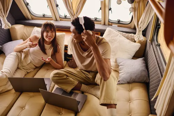 A man and a woman working on laptops while sitting on a couch. — Stock Photo