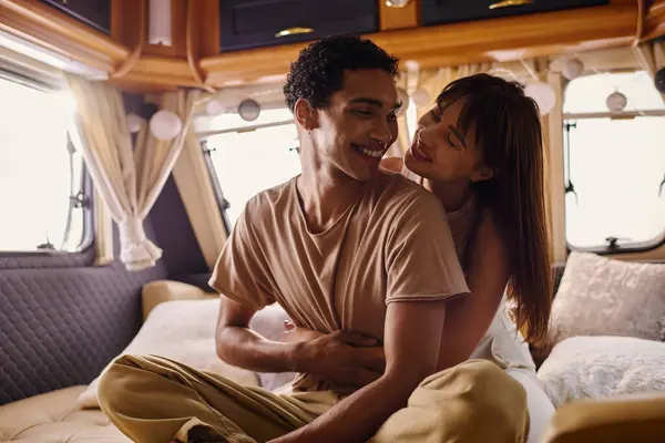 A man and a woman sit closely on a bed, sharing intimate moments in a cozy setting. — Stock Photo