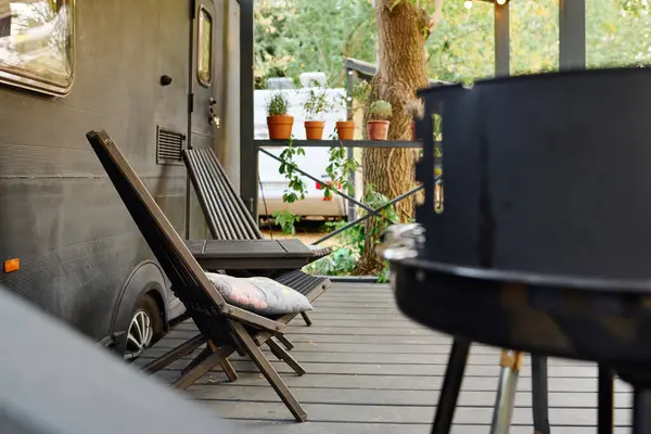 Deck mit Wohnmobil, Grill und Stühlen, ein romantisches Wochenende in der Natur. — Stockfoto