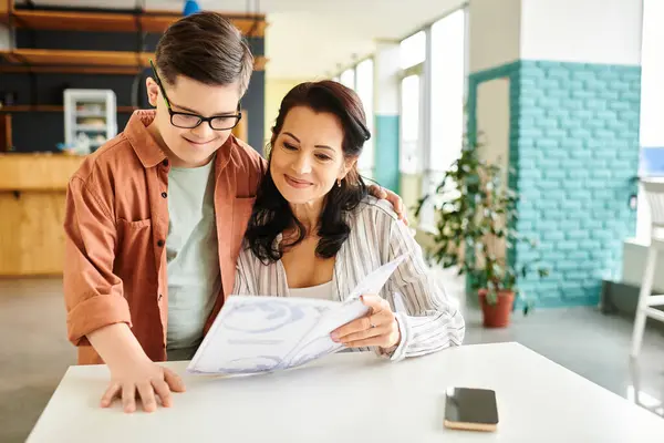 Attractive jolly mother in casual clothes with her inclusive son with Down syndrome holding menu — Stock Photo