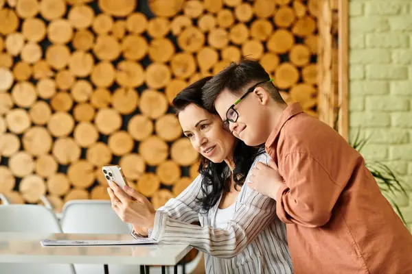Joyful mother in cozy clothes near son with Down syndrome with menu looking at smartphone, selfie — Stock Photo