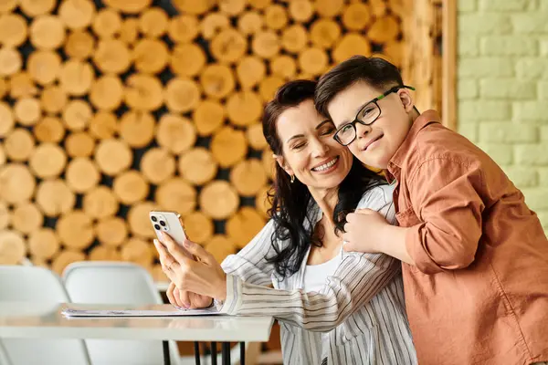 Menino alegre com síndrome de Down passar o tempo com sua bela mãe no café com telefone e menu — Fotografia de Stock