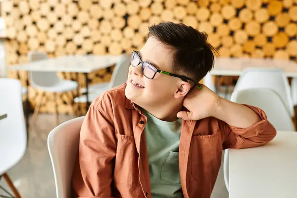 Menino inclusivo pré-adolescente alegre com síndrome de Down em traje casual olhando para longe, enquanto no café — Fotografia de Stock