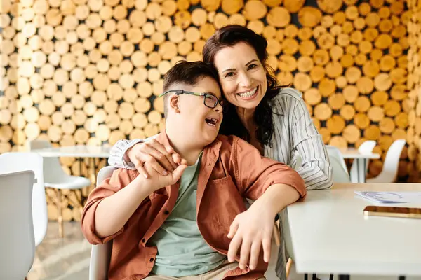 Attractive jolly mother looking at camera while spending time with her son with Down syndrome — Stock Photo