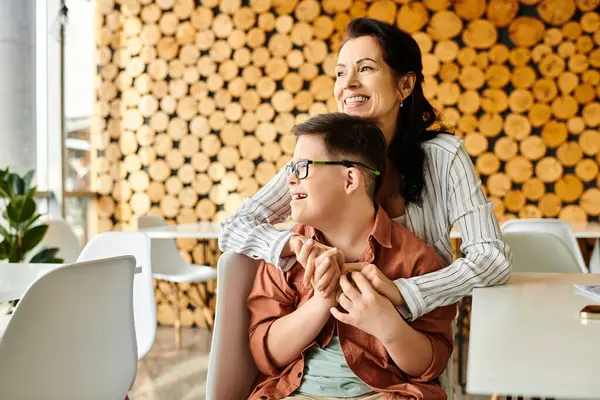Loving beautiful mother having great time with her inclusive jolly son with Down syndrome in cafe — Stock Photo