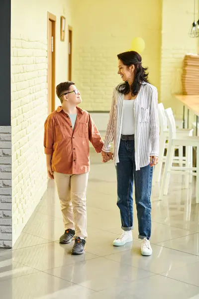 Cheerful adorable preteen inclusive boy with Down syndrome posing with his beautiful jolly mother — Stock Photo