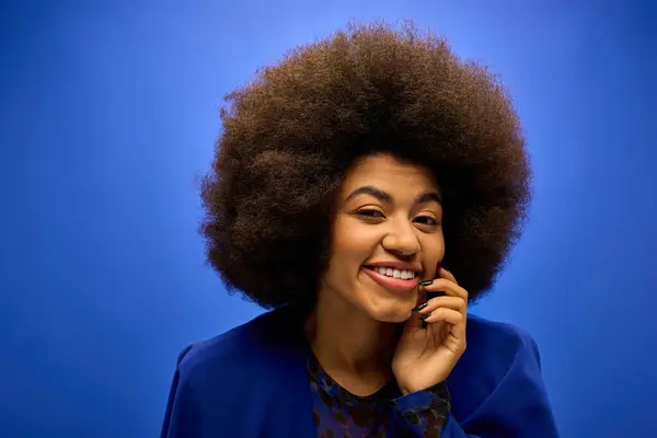 Trendy African American woman with curly hairdo talking on cell phone. — Stock Photo