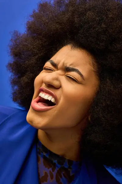 Une vue rapprochée d'une personne afro-américaine élégante présentant une coiffure afro audacieuse dans un contexte vibrant. — Photo de stock