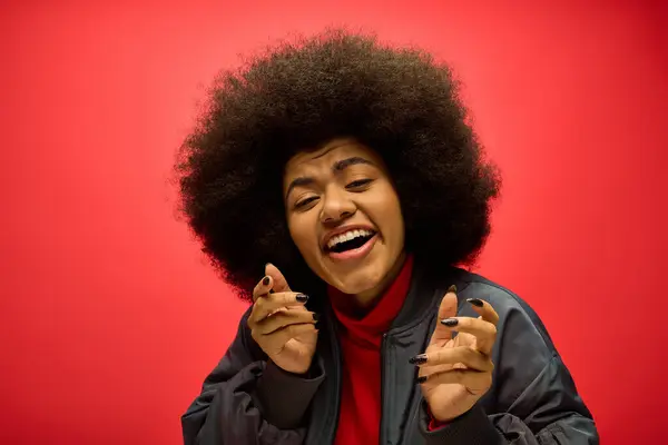 A woman with a voluminous afro hairdo is humorously contorting his face. — Stock Photo