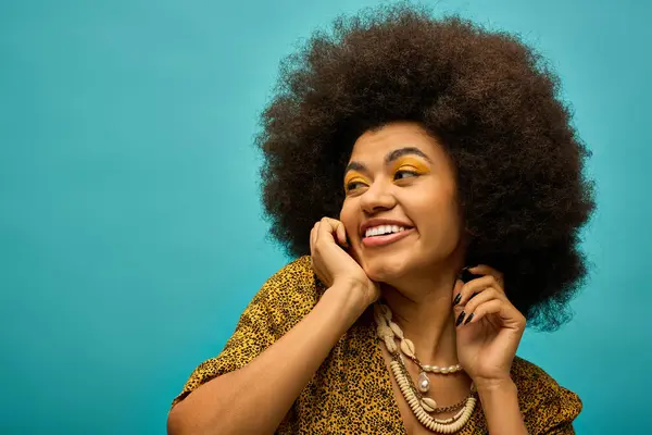 Stylish African American woman with curly hairdosmiling for the camera in trendy attire. - foto de stock