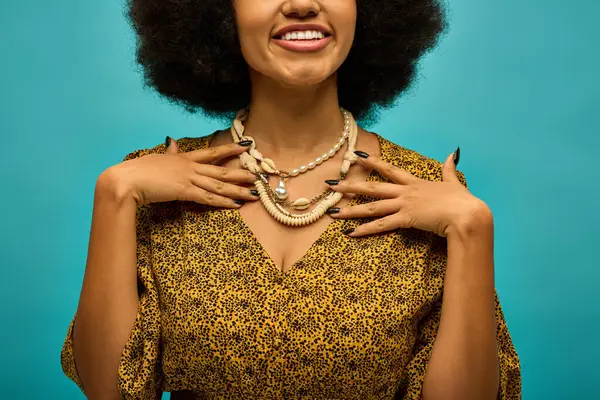 Stylish African American woman with curly hairdoposes on vibrant backdrop. — Stock Photo
