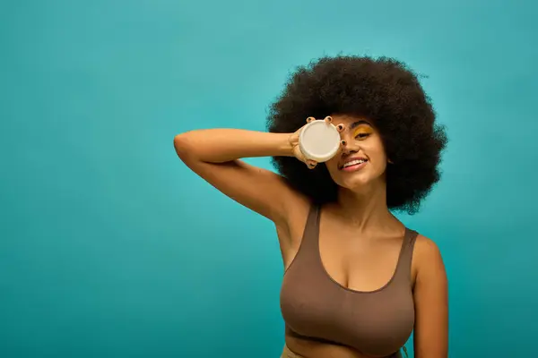 Stylish woman with curly hairdo holding cream. — Stock Photo