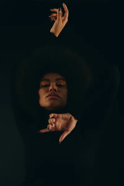 Стильная афроамериканка с поднятой в воздух рукой на ярком фоне. — стоковое фото