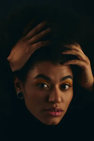 Elegante donna afroamericana in abiti alla moda, mani sulla testa, su uno sfondo vibrante. — Foto stock