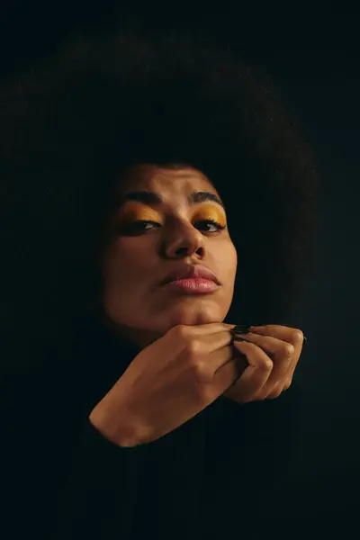 Elegante donna afroamericana in brillanti ombretti gialli sullo sfondo nero. — Foto stock
