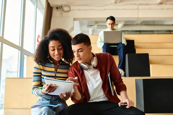 A man and woman sit on a bench, engrossed in a study. They appear to be exploring something together — Stock Photo