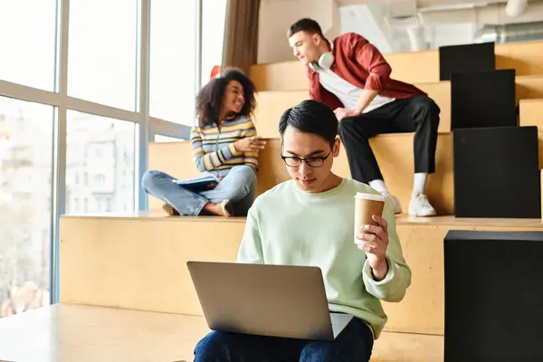 A woman of African American descent relaxes on steps with a laptop and coffee cup — Stock Photo