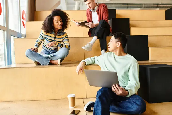 Un groupe multiculturel d'étudiants, y compris une fille noire, assis sur des marches dans un environnement d'apprentissage — Photo de stock