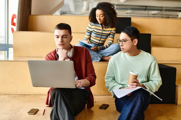 Multicultural group of individuals sitting on stairs, focused on their laptops, engaged in educational activities — Stock Photo