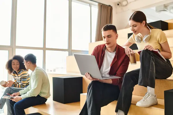 A group of students from various backgrounds sitting and conversing on a colorful set of stairs indoors — Stock Photo