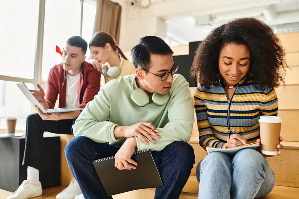 Group of multicultural students, including an African American girl, sitting together on stairs — Stock Photo