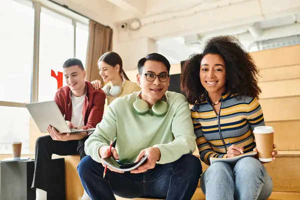 A group of diverse students, including a black girl, sit together on top of a rustic wooden floor indoors. — Stock Photo