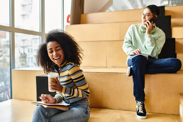 A multicultural woman, possibly a student, sits on steps, engrossed in conversation on her cell phone. — Stock Photo