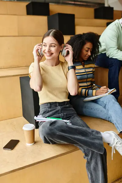 Uma mulher multicultural, possivelmente uma estudante afro-americana, senta-se em passos falando em um telefone celular. — Fotografia de Stock