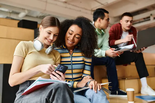 Multicultural students sitting together, engrossed in content on a cell phone screen, focusing intently on the device. — Stock Photo