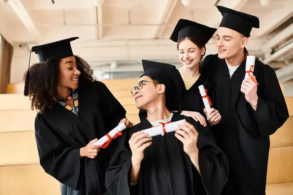 Un gruppo di giovani in abiti da laurea che celebrano i loro successi accademici con sorrisi e gioia. — Foto stock