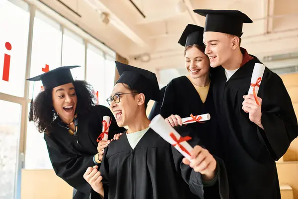 Um grupo diversificado de pessoas em vestidos de graduação, segurando diplomas, celebrando suas realizações acadêmicas com sorrisos. — Fotografia de Stock