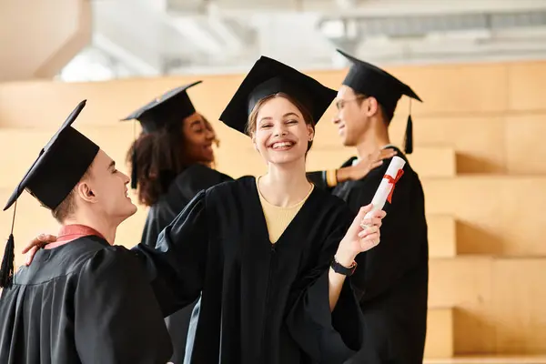 Um grupo diversificado de estudantes em vestidos de graduação e bonés celebrando suas realizações acadêmicas juntos. — Fotografia de Stock