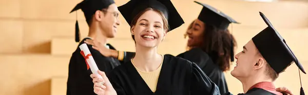 Eine Gruppe glücklicher Studenten in Abschlussmützen und -kleidern feiert ihre akademischen Leistungen bei einer Universitätszeremonie. — Stockfoto