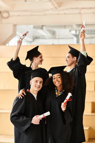 Divers groupes d'étudiants en robes et casquettes de fin d'études posant heureusement pour une image. — Photo de stock