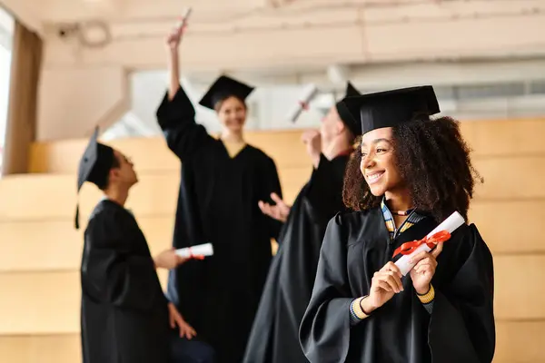 Un groupe diversifié d'étudiants en robes de remise des diplômes et mortiers célèbrent l'achèvement de leur voyage scolaire avec des sourires. — Photo de stock