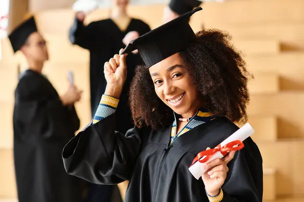 Un groupe diversifié de diplômés célèbrent joyeusement dans leurs casquettes et robes lors d'une cérémonie de remise des diplômes universitaires. — Photo de stock
