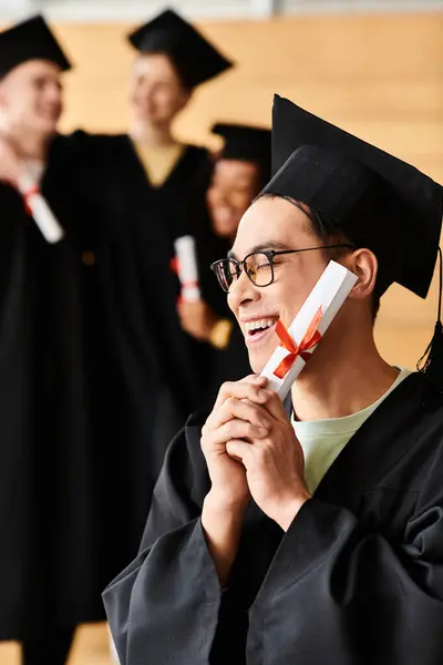 Homme asiatique portant fièrement une casquette et une robe de graduation, symbolisant la réussite scolaire et le succès. — Photo de stock