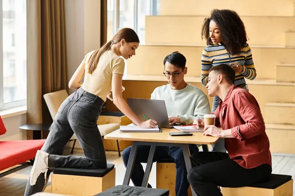 A group of diverse students sit happily around a wooden table, engaging in an educational discussion. — Stock Photo