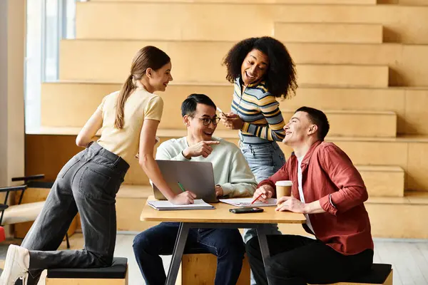 Students of various backgrounds sit together at a wooden table, engaged in conversation and teamwork. — Stock Photo